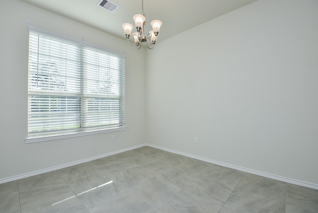 unfurnished room with an inviting chandelier