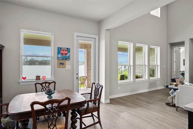 dining space with a water view and light hardwood / wood-style flooring