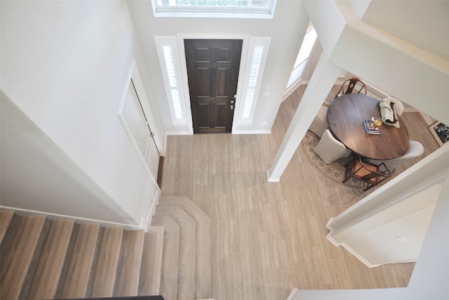 entrance foyer with a towering ceiling and light hardwood / wood-style floors