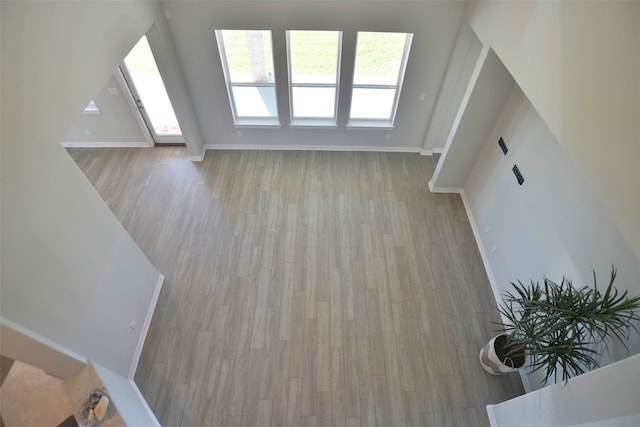 living room featuring a towering ceiling and light wood-type flooring