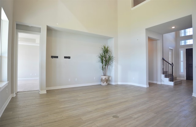 interior space featuring light hardwood / wood-style flooring and a high ceiling