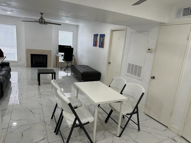 dining area with a textured ceiling and ceiling fan