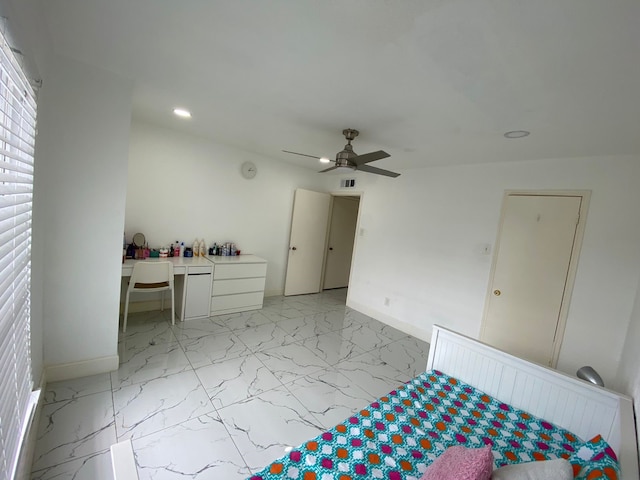 unfurnished bedroom with ceiling fan and built in desk