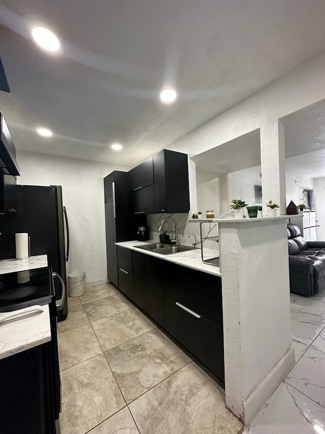 kitchen featuring kitchen peninsula, sink, and black range oven