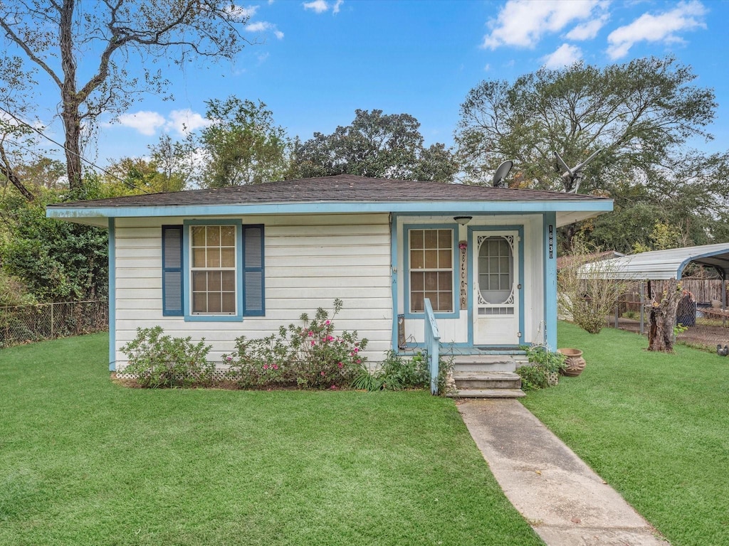 view of front of house with a front yard and a carport