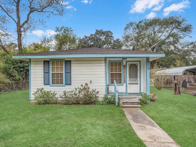 view of front of house with a front yard and a carport