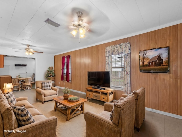 living room featuring ceiling fan, crown molding, and wooden walls