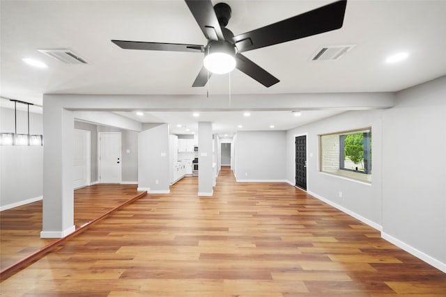 unfurnished living room featuring ceiling fan and light hardwood / wood-style floors