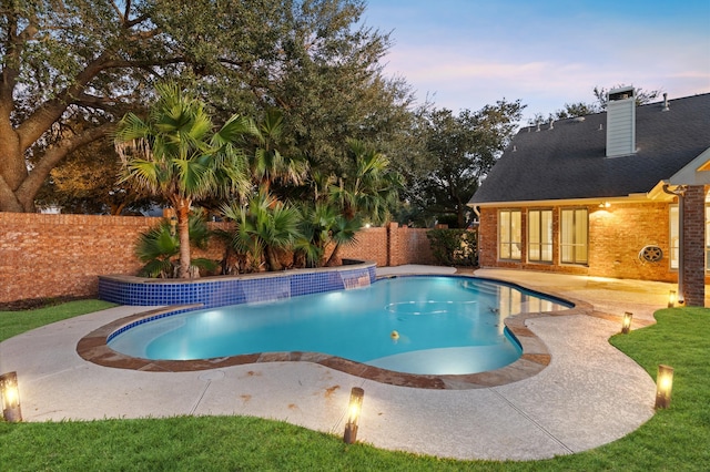 pool at dusk featuring a patio