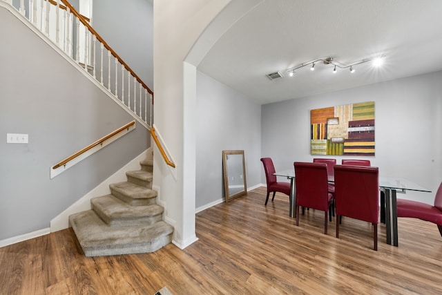 dining area with hardwood / wood-style floors and rail lighting