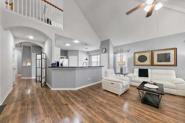 living room with ceiling fan, dark wood-type flooring, and high vaulted ceiling