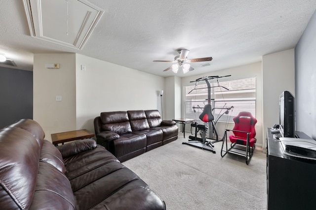 carpeted living room with ceiling fan and a textured ceiling