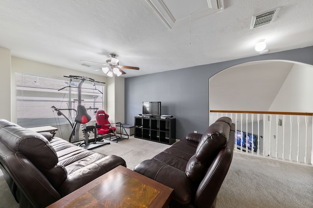 living room with a textured ceiling, light colored carpet, and ceiling fan