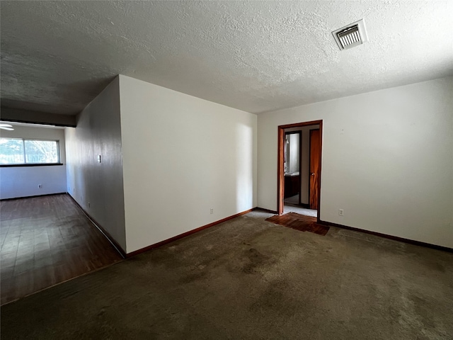 empty room featuring dark hardwood / wood-style flooring and a textured ceiling