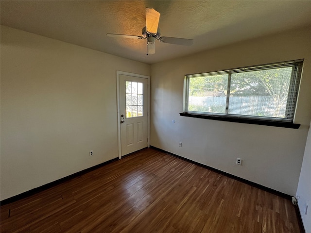 unfurnished room featuring a textured ceiling, dark hardwood / wood-style floors, and ceiling fan