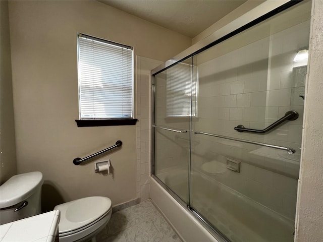 bathroom with shower / bath combination with glass door and toilet