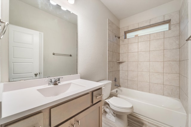 full bathroom with vanity, toilet, tiled shower / bath, and hardwood / wood-style flooring