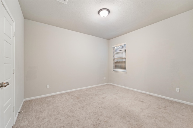 empty room featuring light carpet and a textured ceiling