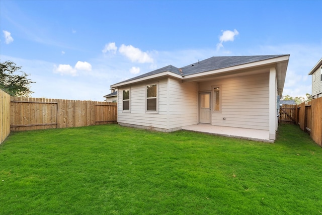 rear view of property featuring a yard and a patio area