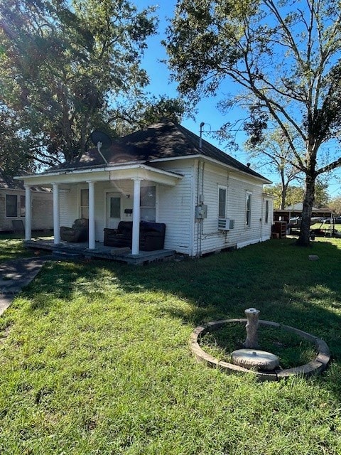 view of side of property with a lawn, cooling unit, and a porch