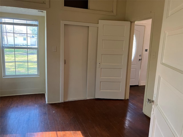 unfurnished bedroom featuring a closet and dark wood-type flooring