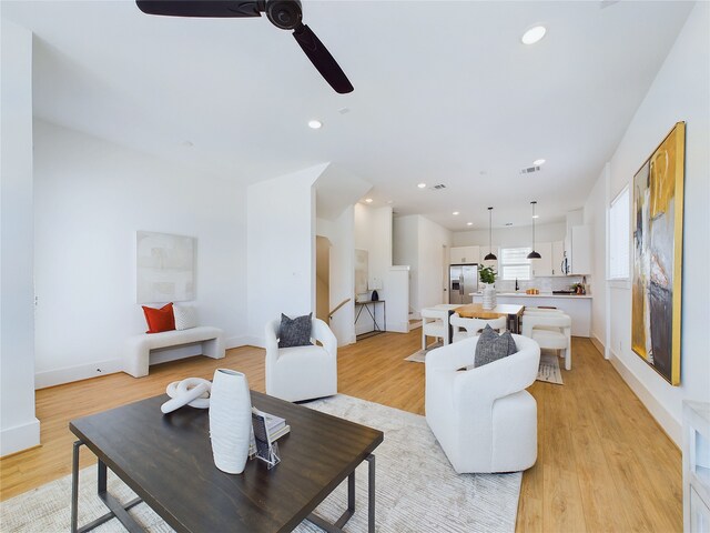 living room with ceiling fan and light wood-type flooring