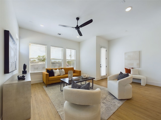 living room with ceiling fan and light hardwood / wood-style flooring