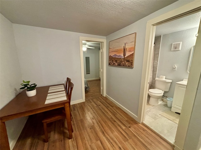 interior space featuring ceiling fan, light hardwood / wood-style floors, and a textured ceiling