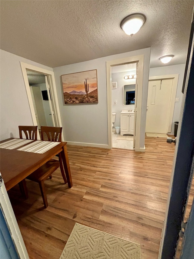 hallway featuring a textured ceiling and light wood-type flooring