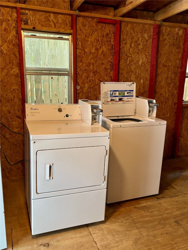 laundry room with separate washer and dryer and light hardwood / wood-style flooring