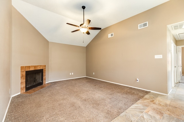 unfurnished living room with a tiled fireplace, ceiling fan, light colored carpet, and vaulted ceiling