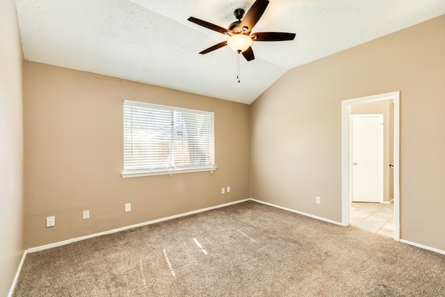 empty room with light carpet, a textured ceiling, vaulted ceiling, and ceiling fan