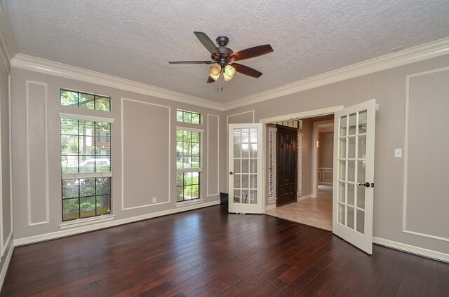 empty room with ceiling fan, french doors, dark wood-type flooring, a textured ceiling, and ornamental molding