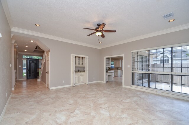 spare room featuring a textured ceiling, ceiling fan, and ornamental molding