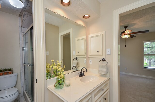 bathroom featuring vanity, a textured ceiling, toilet, and walk in shower