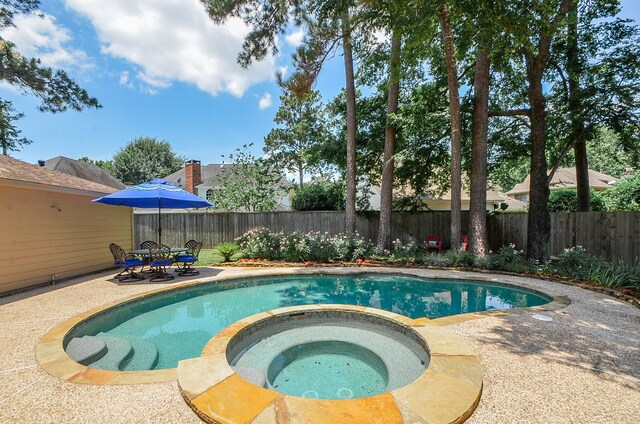 view of pool featuring an in ground hot tub and a patio