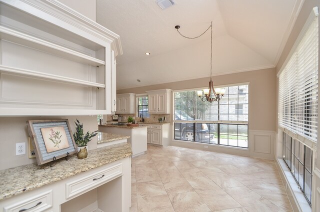 kitchen with light stone counters, ornamental molding, vaulted ceiling, decorative light fixtures, and a chandelier