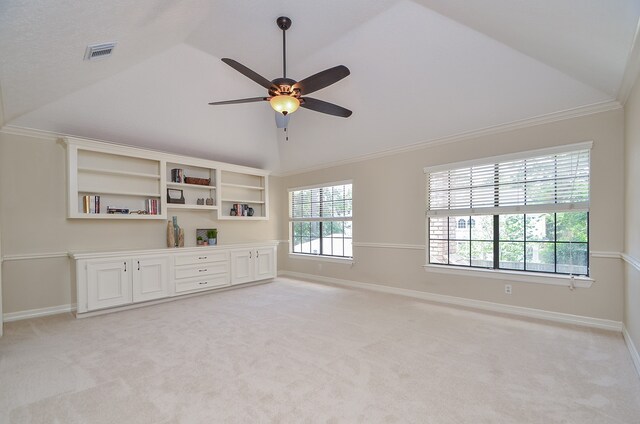 carpeted empty room featuring ceiling fan, ornamental molding, and lofted ceiling