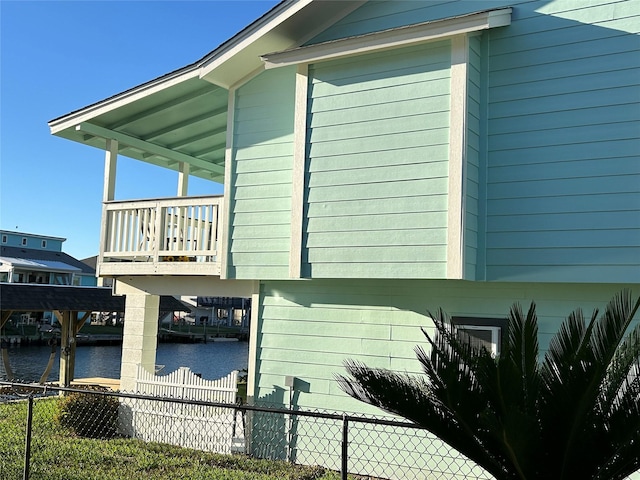 view of home's exterior with a water view and a dock