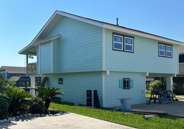 rear view of house featuring a balcony and a patio