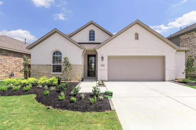 french country style house featuring a garage, brick siding, and concrete driveway