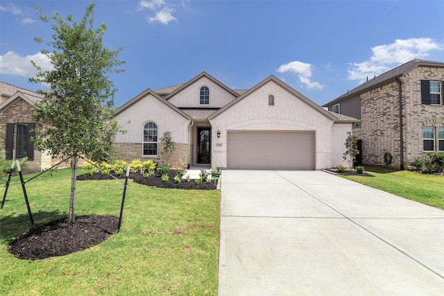view of front of property with concrete driveway, brick siding, a front yard, and a garage