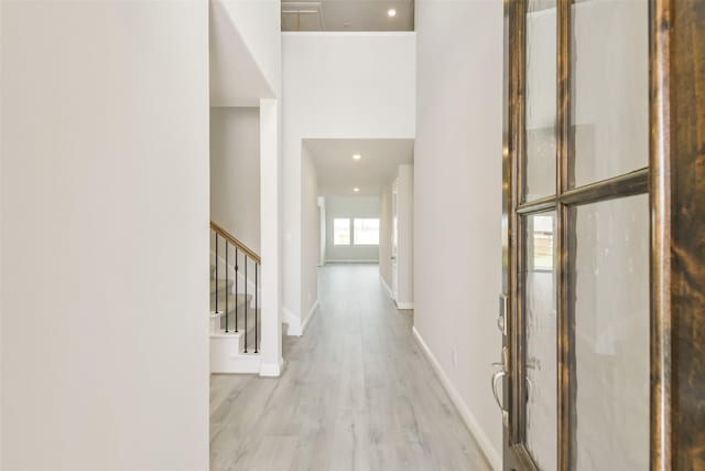 hall featuring baseboards, stairs, wood finished floors, and recessed lighting