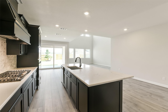 kitchen featuring visible vents, a sink, light wood-style flooring, appliances with stainless steel finishes, and custom exhaust hood