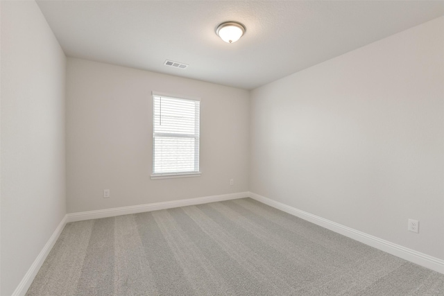 carpeted empty room featuring visible vents and baseboards