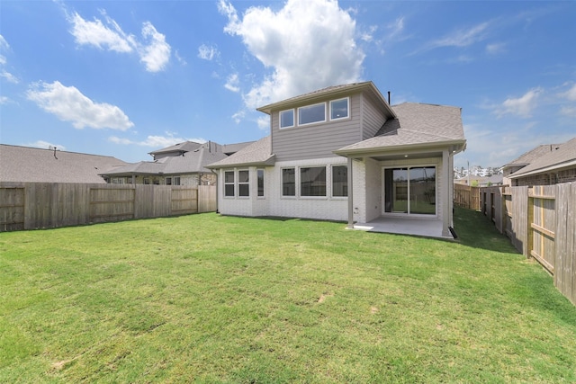 rear view of property with a lawn, a fenced backyard, and a patio