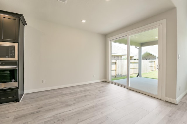 unfurnished living room featuring baseboards, visible vents, and light wood finished floors