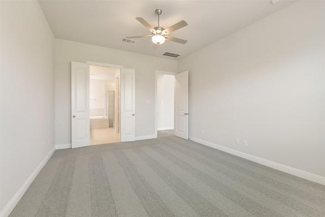 unfurnished bedroom featuring baseboards, visible vents, carpet floors, and connected bathroom