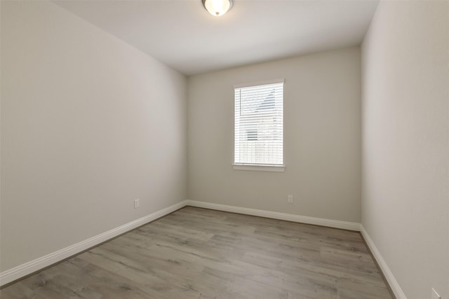 empty room with baseboards and wood finished floors