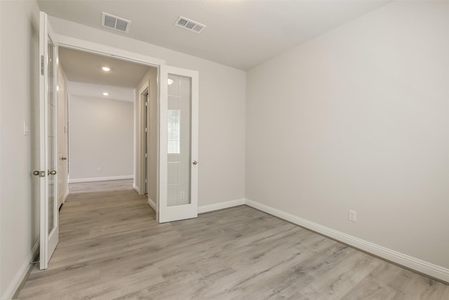 spare room featuring light wood finished floors, baseboards, visible vents, and recessed lighting